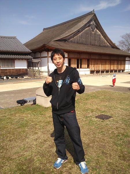 篠山城大書院の前でガッツポーズをしている角谷 淳志選手の写真
